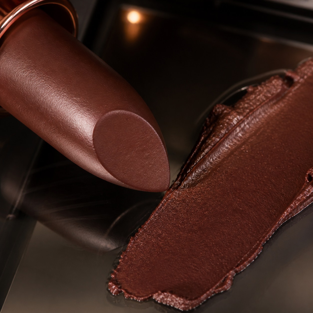 Close view of brown lipstick showing the formula texture