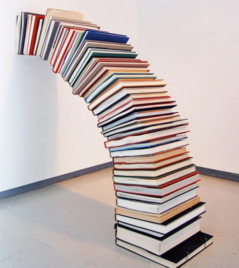 Gravity-defying arch of stacked books against a wall