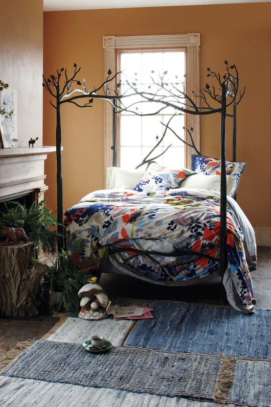 Branch-like metal canopy bed with floral bedding in a terracotta room