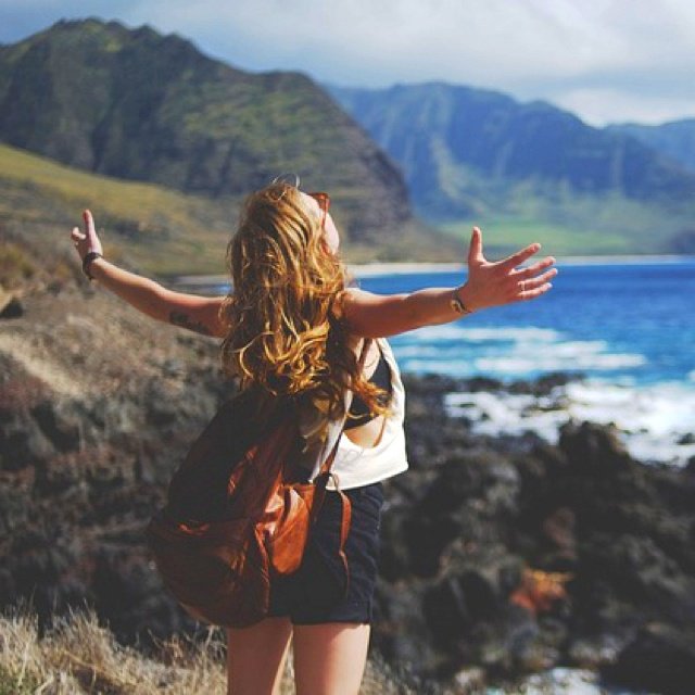 Open-armed pause on a rocky coastline