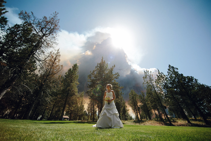 Bride and groom portrait with Two Bulls fire visible in the distance