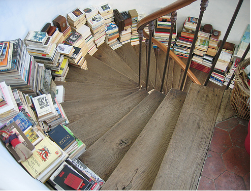 Spiral stair with books stacked along the steps