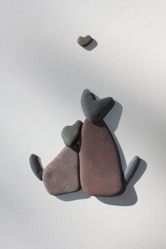 Two pebble cats with a heart stone above