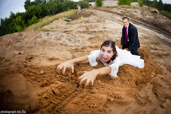 Bride clawing through dirt while the groom smiles behind her