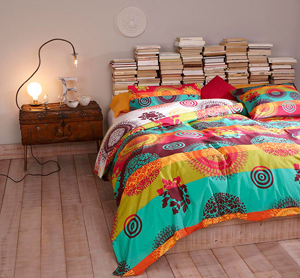 Stacks of books used as a bedroom headboard