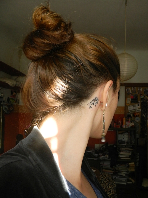 howling wolf silhouette tattoo behind the ear