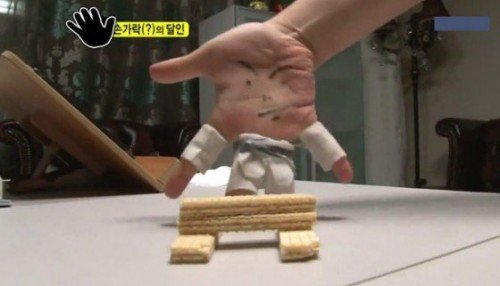 Hand dressed as a tiny martial artist breaking wafer cookie boards