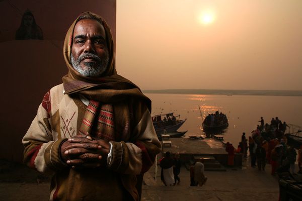 Man in patterned sweater by the river at golden hour