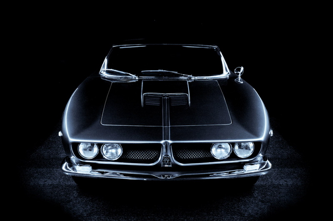 Polished vintage car against black backdrop