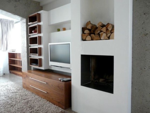 Modern living wall with fireplace, firewood niche, and media storage