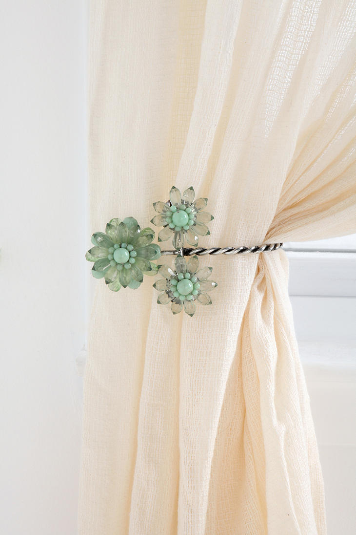 Curtain held with decorative tieback
