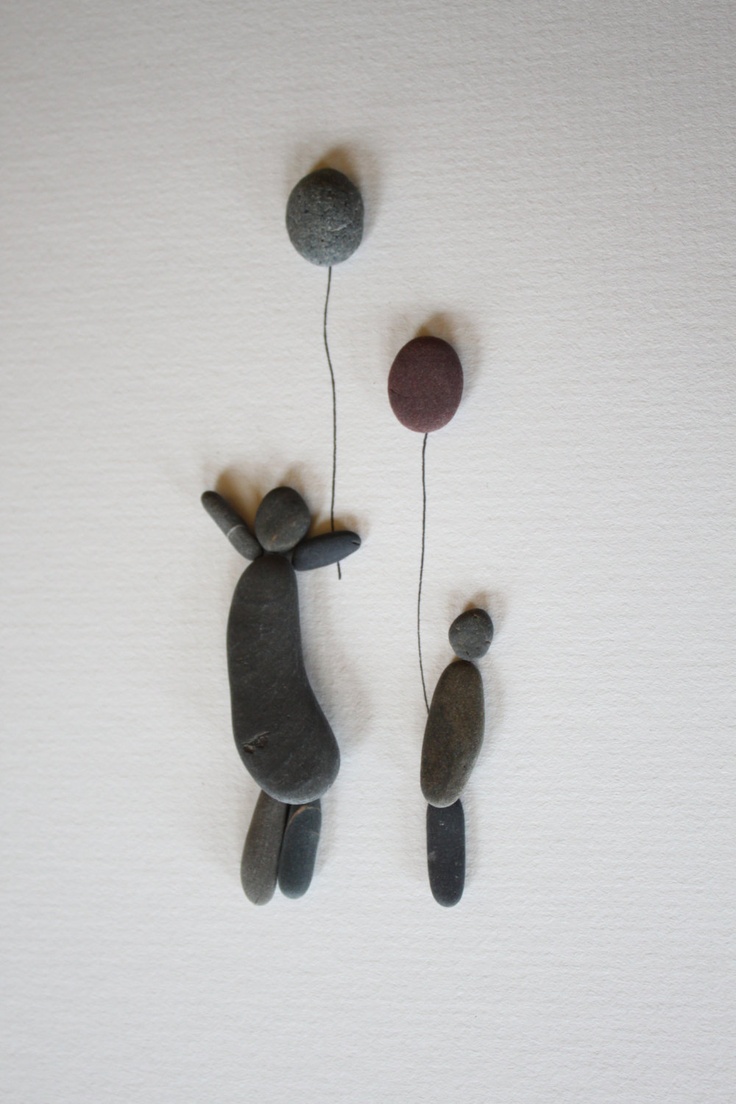 Adult and child pebble figures with balloons