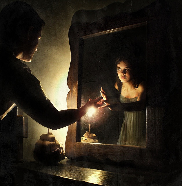 Woman studying her reflection in a quiet interior