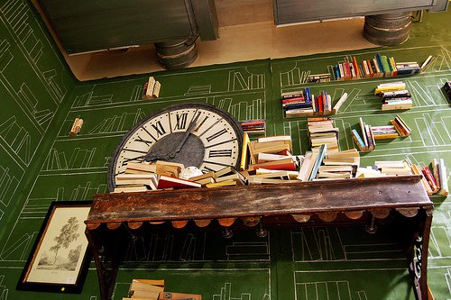 Trompe-l’oeil painted library with real books and clock