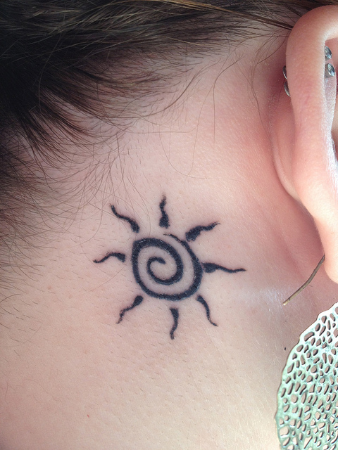 spiral sun tattoo behind the ear