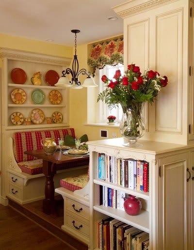 Cream cabinetry nook with plate rack drawers and red accents