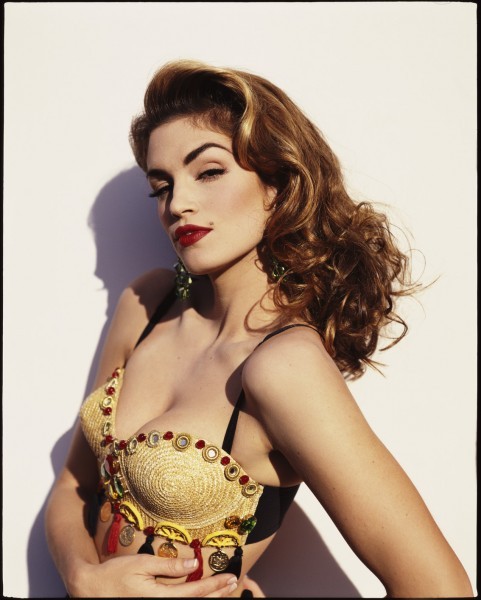Supermodel-era studio portrait with embellished woven top and strong profile shadow