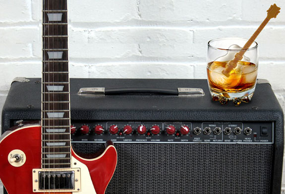 Guitar shaped ice stirrer in an amber drink on an amplifier