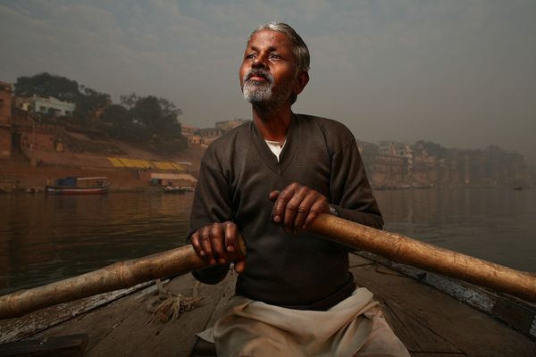 Boatman holding oars on a hazy river