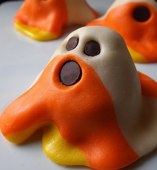 Candy-corn colored ghost treats with chocolate faces