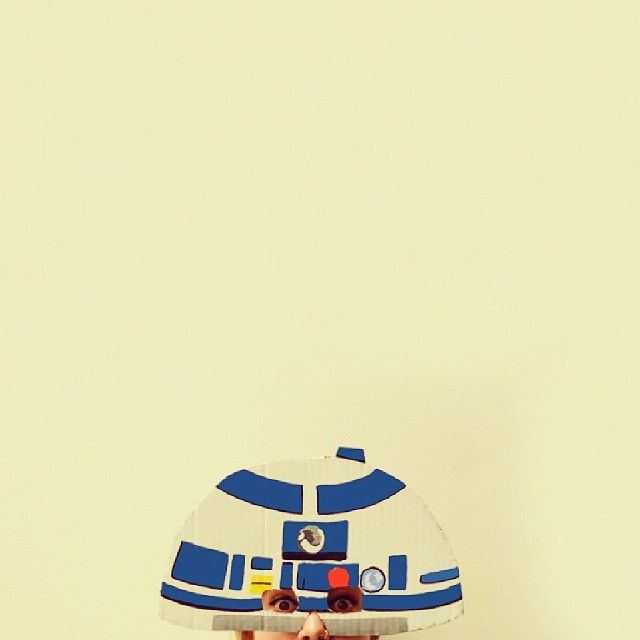 R2-D2 cardboard dome mask peering into frame
