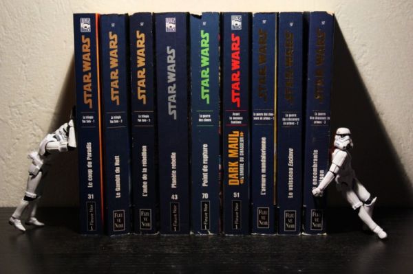 Two stormtroopers holding up a row of French Star Wars paperbacks