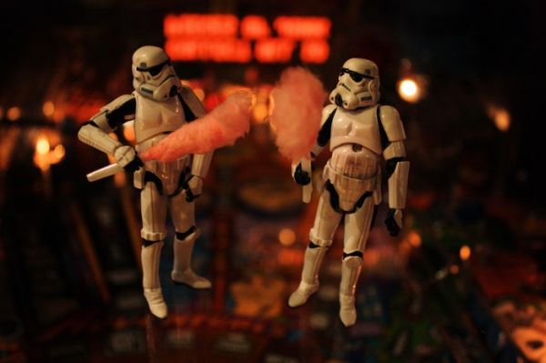 Two stormtroopers holding pink cotton candy on a pinball machine