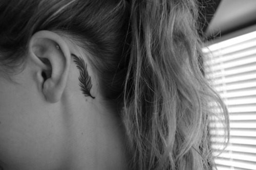 black feather tattoo behind the ear