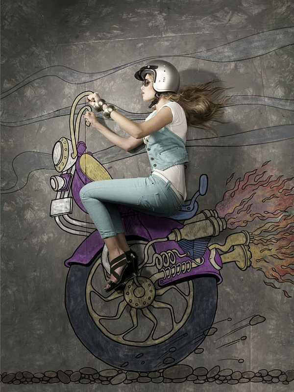 Woman in motorcycle gear posed with a chalk-drawn flaming bike from overhead