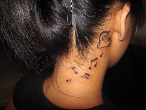 Scattered music notes tattoo