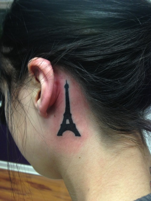 Eiffel Tower silhouette tattoo behind the ear