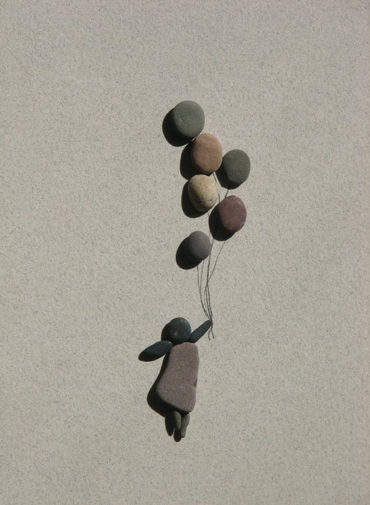 Pebble figure floating with stone balloons