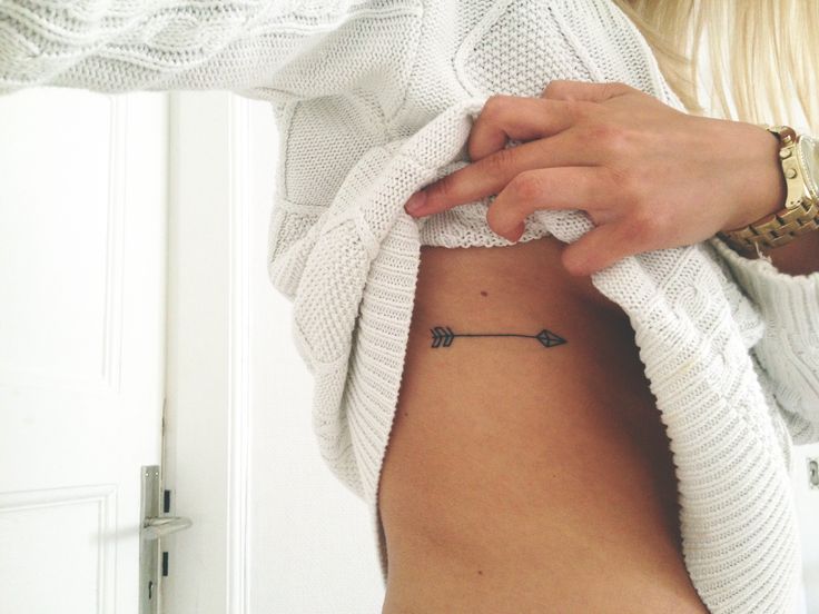 Arrow tattoo with floral elements