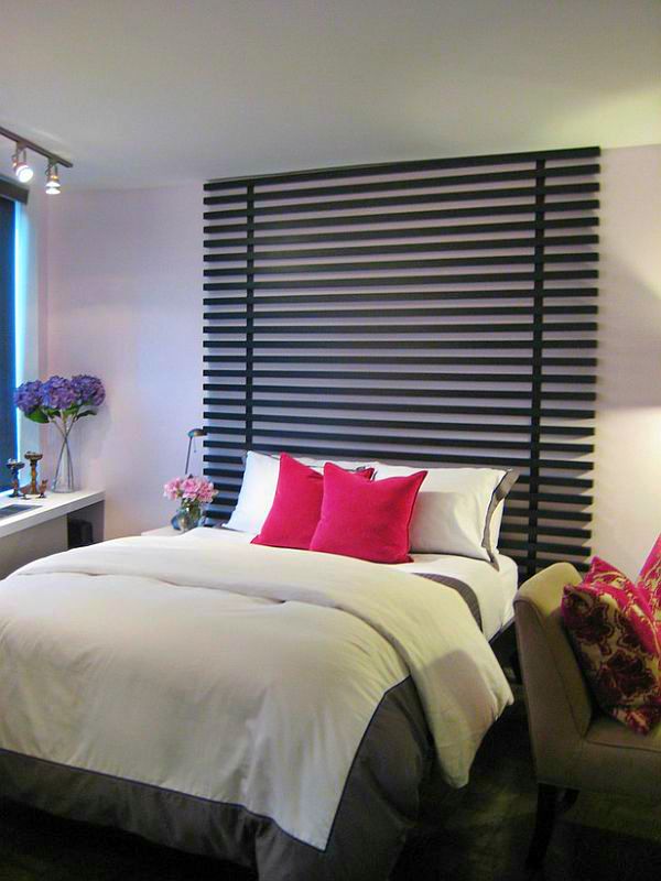 Tall dark wood slat headboard on a pale wall