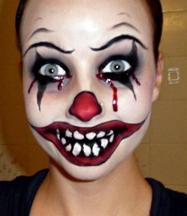 Horror clown makeup with bloody tears and jagged painted teeth