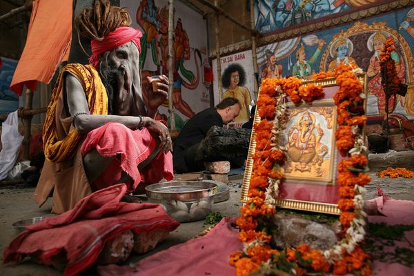 Devotee near a marigold-draped Ganesha shrine