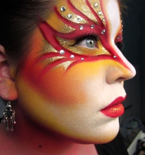 Fire phoenix face paint with gold and rhinestones
