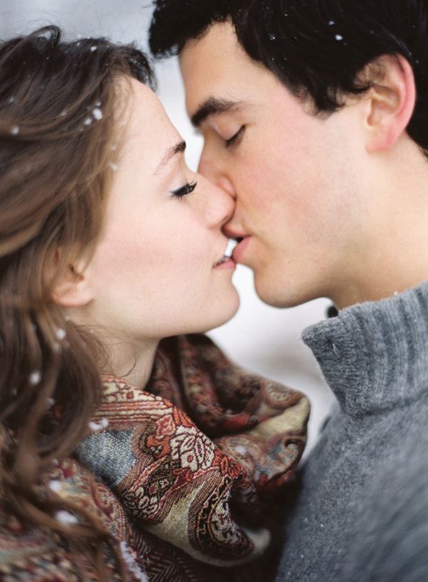 Close-up winter kiss with snowflakes on knitwear