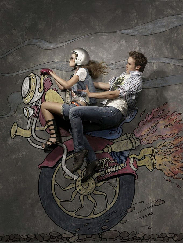 Couple posed as riders on a colorful chalk motorcycle with exhaust flames