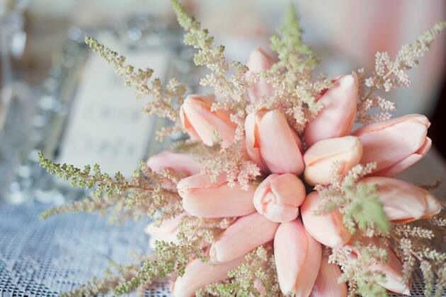 Pink wedding bouquet held against a white dress